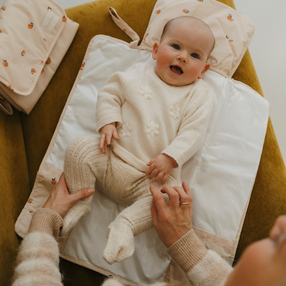 bébé sur le matelas à langer pêche tapilou