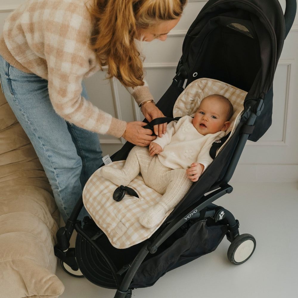 bébé en train d'être installé sur le matelas de poussette vichy tapilou